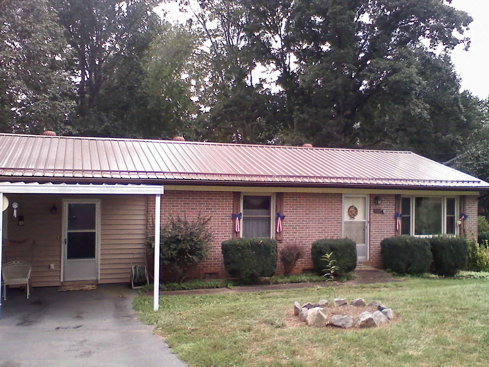 Bronze metal roof and carport on a brick ranch home — Roof Repair work by our crew in Mechanicsburg
